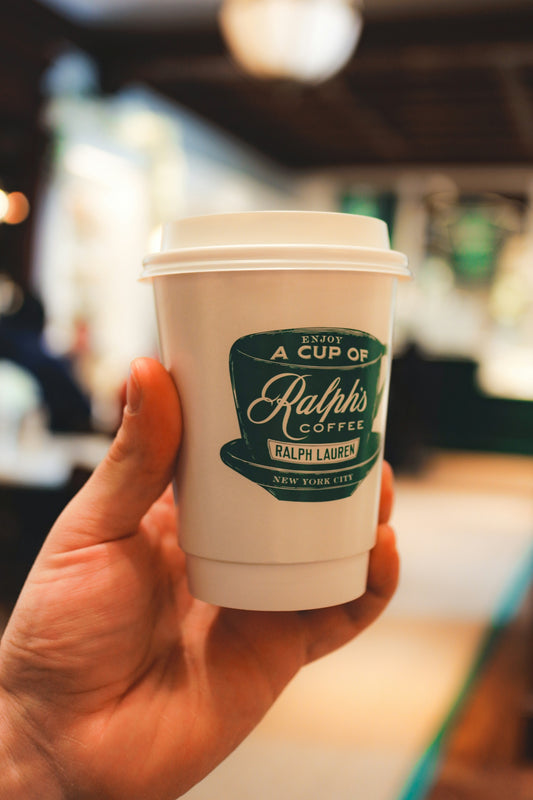 A hand holds a cup of ralph's coffee.