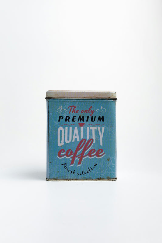 A vintage coffee can sits on a white background.