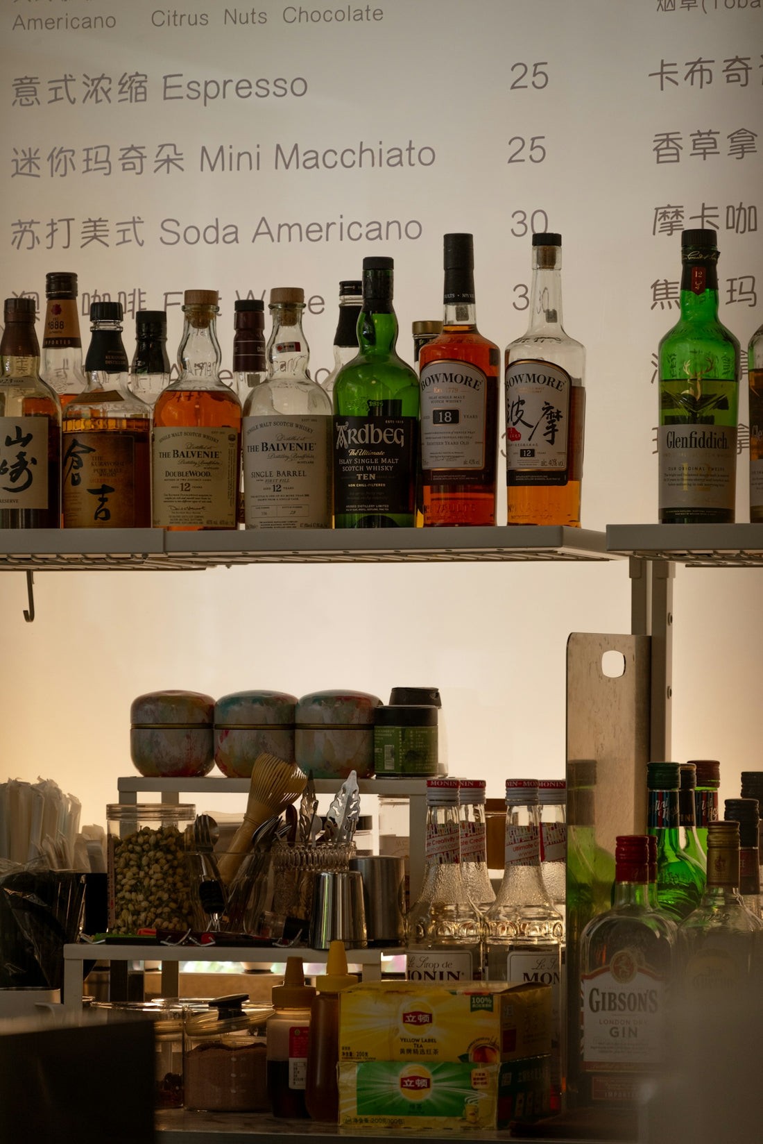 Bottles and drink ingredients are displayed behind a menu.