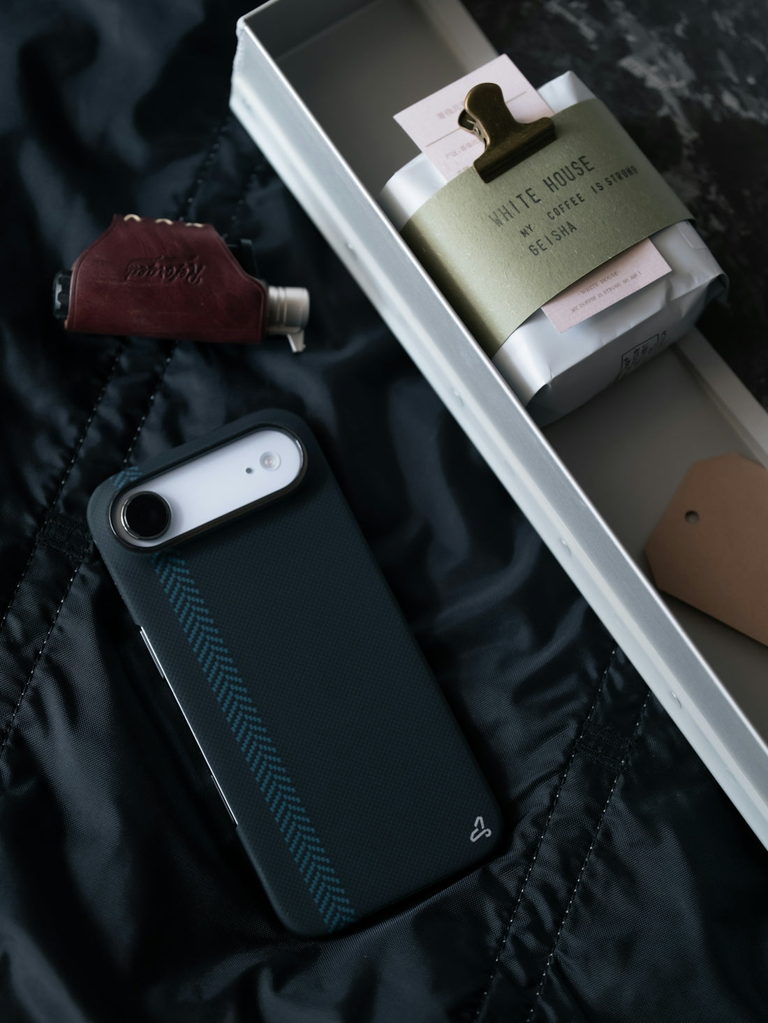 Dark phone case with items in a gift box