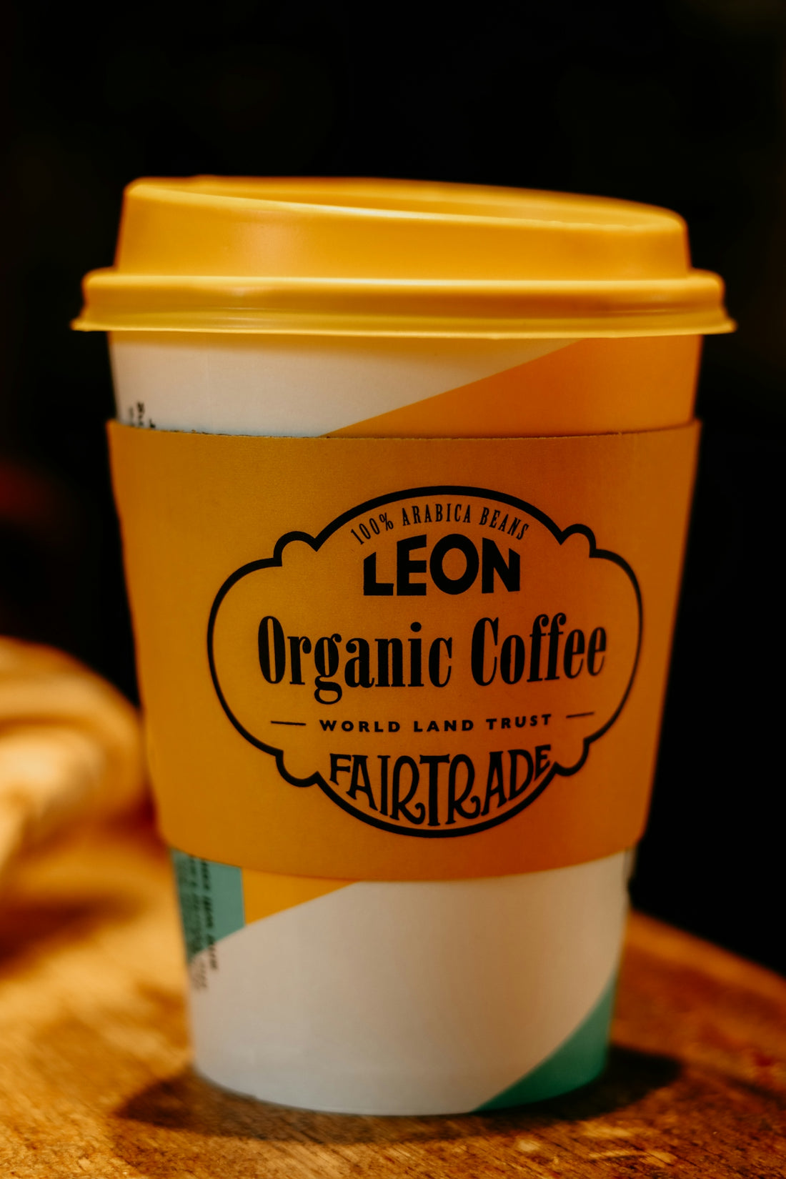 Disposable coffee cup with leon organic coffee branding.