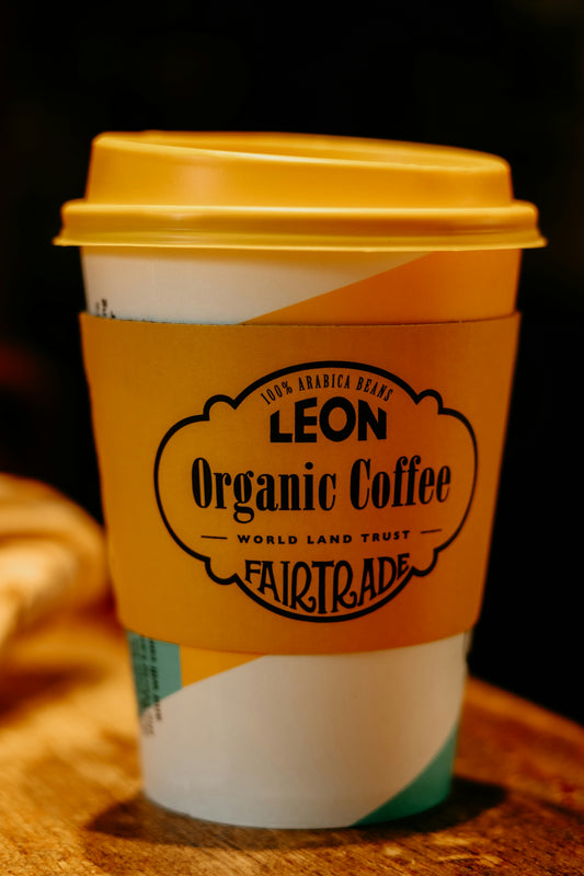 Disposable coffee cup with leon organic coffee branding.