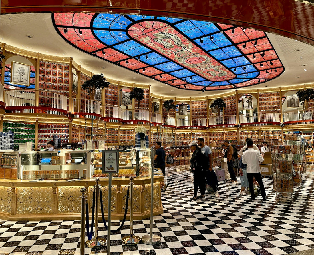 Luxurious store interior with ornate stained-glass ceiling and checkered floor.