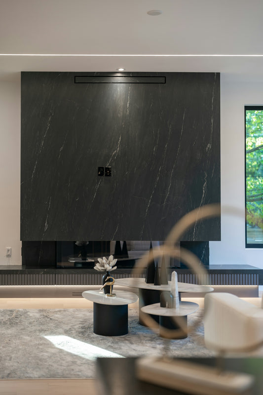 A black marble fireplace wall with modern coffee tables in a living room